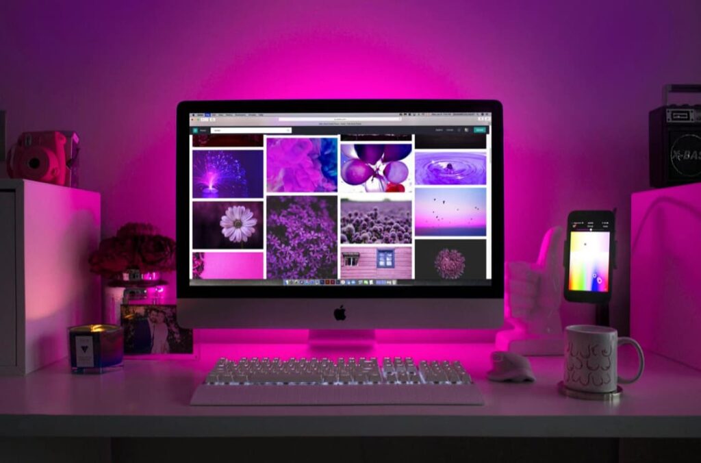 ordinateur rédacteur web SEO écran sur un bureau avec lumière rose